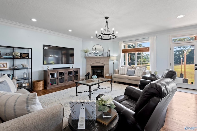 living room featuring crown molding, a textured ceiling, hardwood / wood-style flooring, and a chandelier