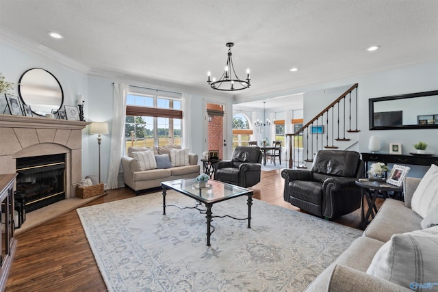 living room with a textured ceiling, ornamental molding, a chandelier, and dark hardwood / wood-style flooring