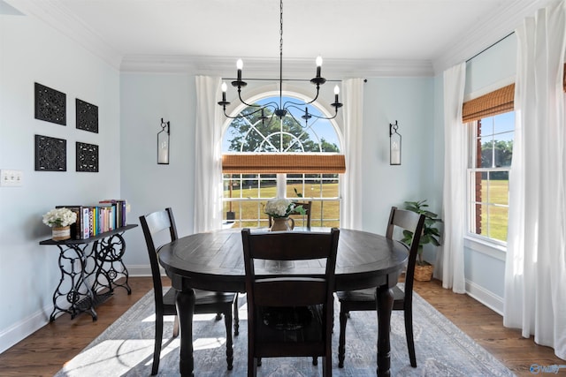 dining room with a notable chandelier, hardwood / wood-style floors, and crown molding