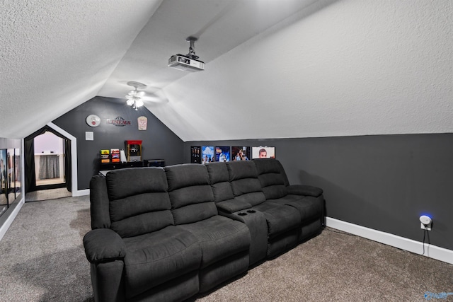 carpeted home theater room with a textured ceiling, ceiling fan, and vaulted ceiling