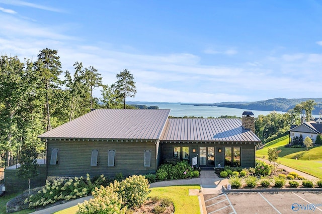 view of front of property with a water and mountain view and a front yard