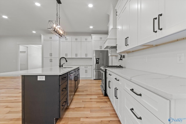 kitchen with white cabinetry, stainless steel appliances, sink, and a kitchen island with sink