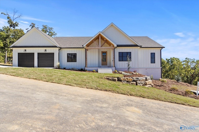 modern farmhouse with a front yard and a garage