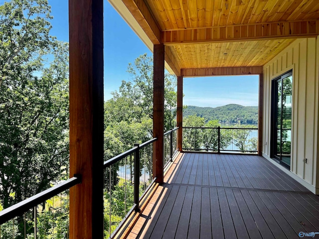 wooden deck with a water and mountain view