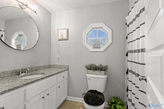 bathroom featuring tile patterned flooring, toilet, and vanity