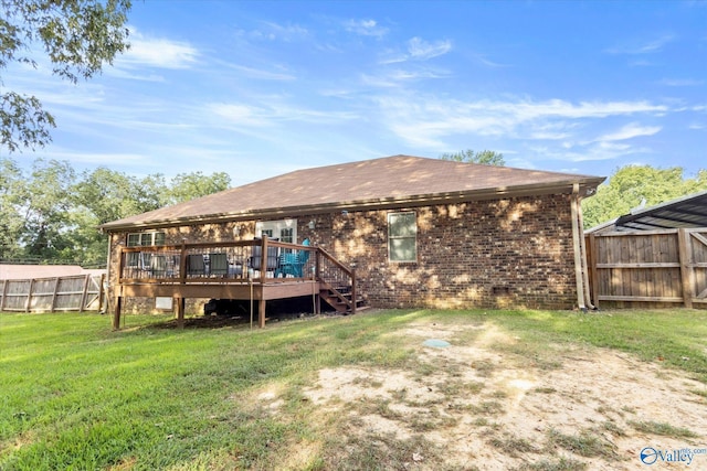 back of property with a deck and a yard