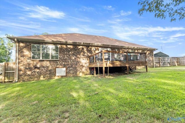 rear view of property with a wooden deck and a lawn