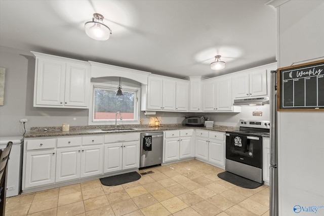 kitchen featuring white cabinets, appliances with stainless steel finishes, sink, dark stone countertops, and light tile patterned flooring