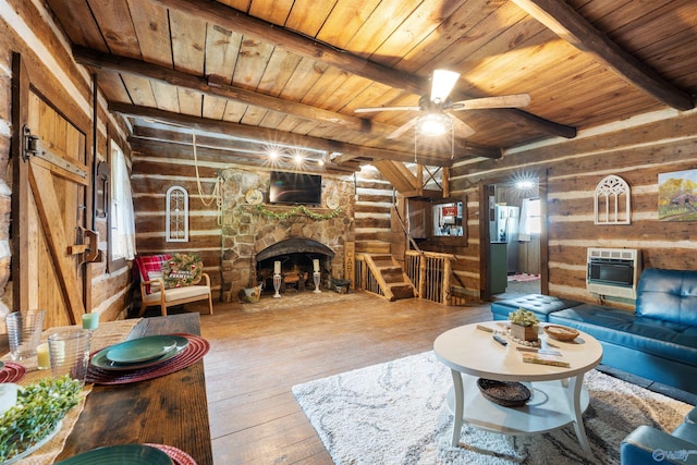 living area with wood-type flooring, wood ceiling, a stone fireplace, and beamed ceiling