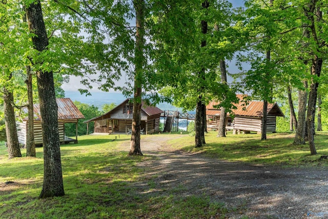 view of front of home featuring a front lawn, an outbuilding, and metal roof