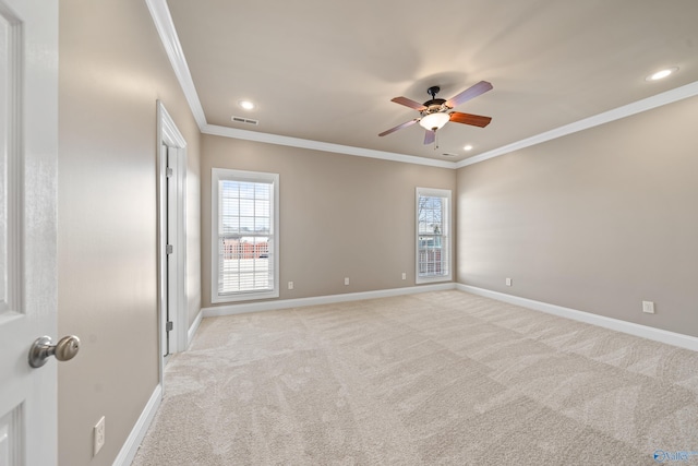 unfurnished room featuring a wealth of natural light, light colored carpet, visible vents, and baseboards