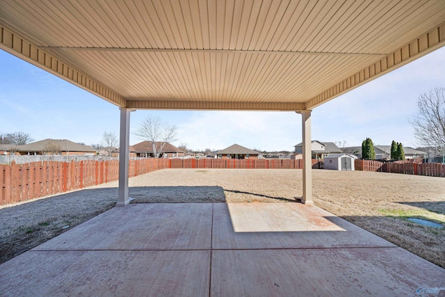 view of patio featuring a fenced backyard, an outdoor structure, and a storage shed