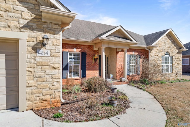 view of front of house featuring stone siding, brick siding, and roof with shingles