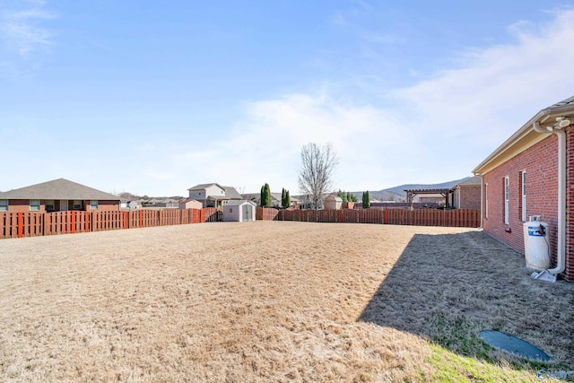 view of yard with an outbuilding, a fenced backyard, and a storage unit