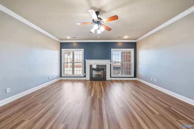 unfurnished living room with baseboards, ornamental molding, wood finished floors, and a high end fireplace