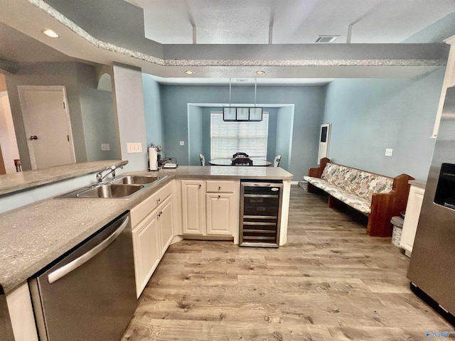 415 County Road 355, Leesburg, AL 35983 - kitchen featuring stainless steel dishwasher, beverage cooler, light wood finished floors, decorative light fixtures, and light countertops