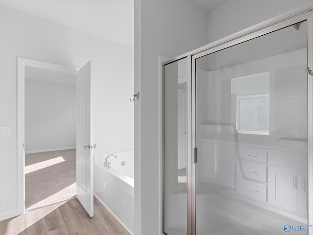 bathroom with wood-type flooring and separate shower and tub