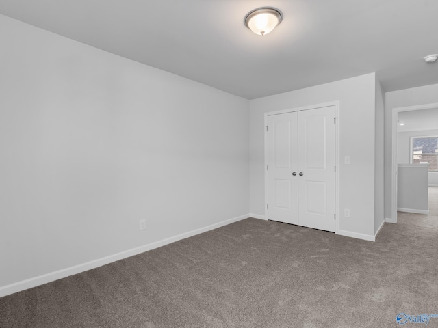 unfurnished bedroom featuring carpet flooring and a closet