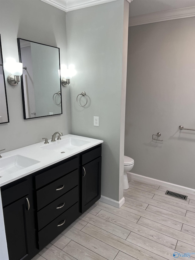 bathroom with wood-type flooring, vanity, toilet, and ornamental molding