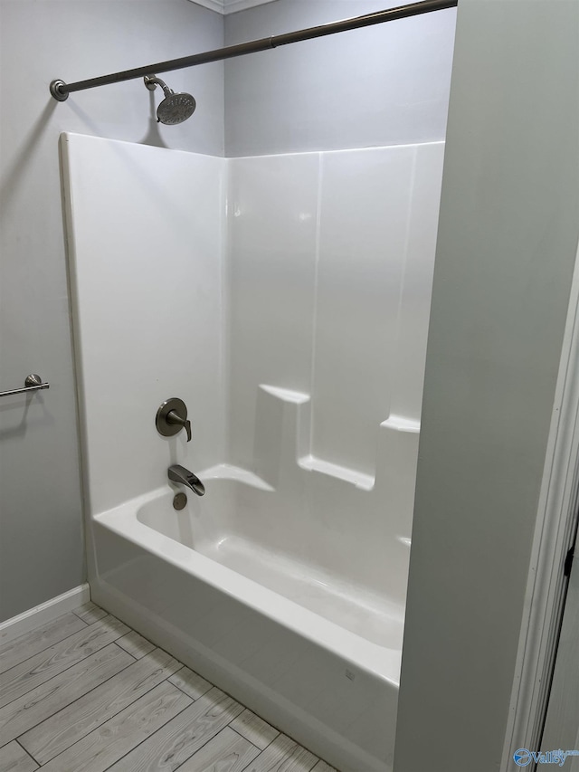 bathroom with wood-type flooring and  shower combination