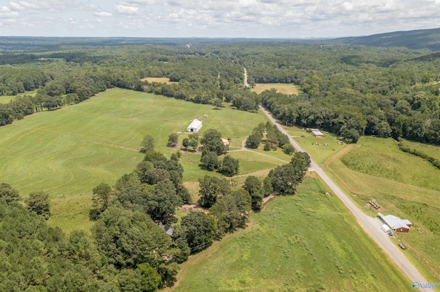 drone / aerial view featuring a view of trees and a rural view