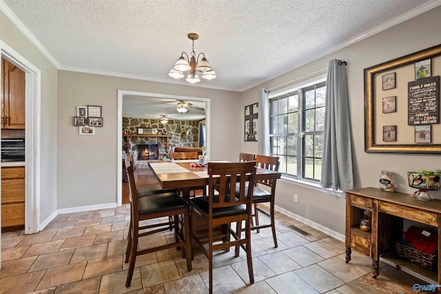 dining space with ceiling fan with notable chandelier, a textured ceiling, a stone fireplace, light tile patterned flooring, and ornamental molding