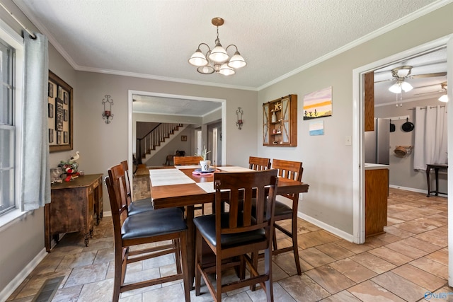 tiled dining area with a textured ceiling, crown molding, and ceiling fan with notable chandelier