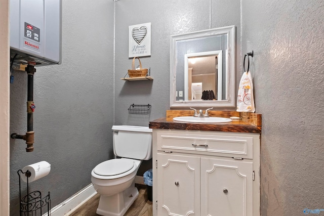 bathroom with wood-type flooring, vanity, and toilet