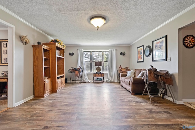 sitting room featuring crown molding, wood-type flooring, and a textured ceiling