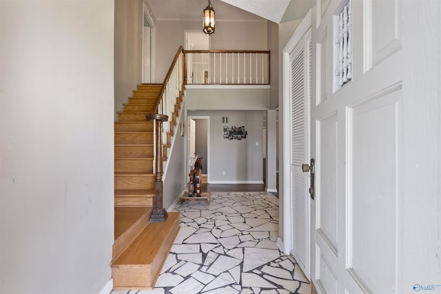 entrance foyer featuring a towering ceiling, stairs, and baseboards