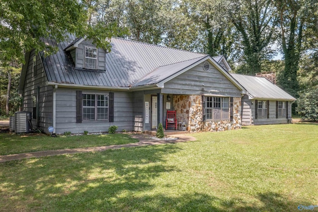 view of front of home featuring metal roof, a front yard, and central air condition unit