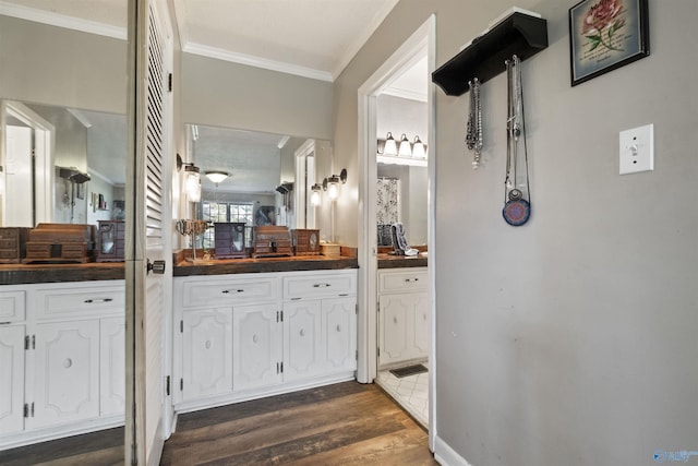 bathroom with visible vents, ornamental molding, wood finished floors, and vanity