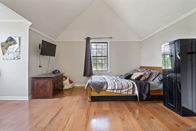 bedroom featuring high vaulted ceiling, light wood-type flooring, crown molding, and baseboards