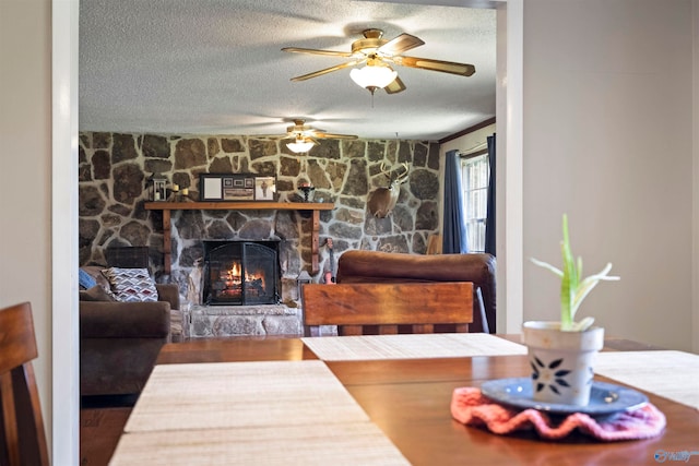 living room with hardwood / wood-style floors, a fireplace, a textured ceiling, and ceiling fan