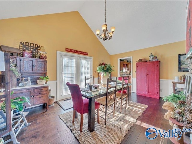 dining area with an inviting chandelier, high vaulted ceiling, and dark hardwood / wood-style floors