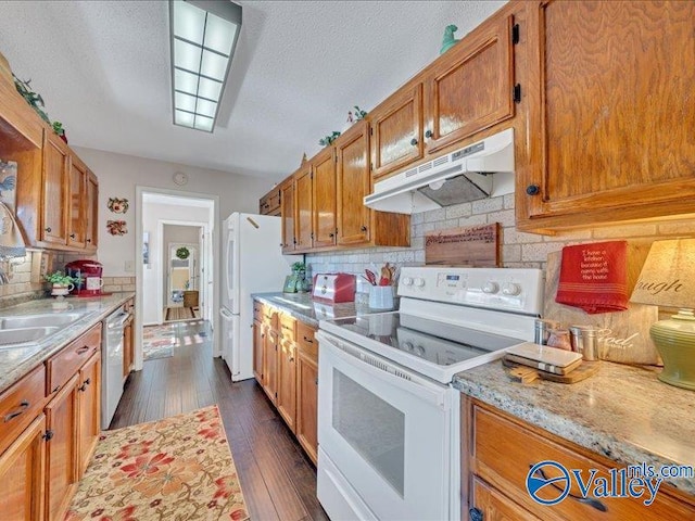 kitchen with backsplash, white appliances, dark hardwood / wood-style floors, and sink