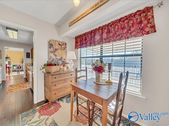 dining area featuring dark hardwood / wood-style floors, a textured ceiling, and a wealth of natural light