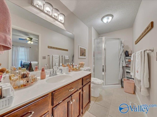 bathroom featuring vanity, a shower with shower door, tile patterned floors, and a textured ceiling