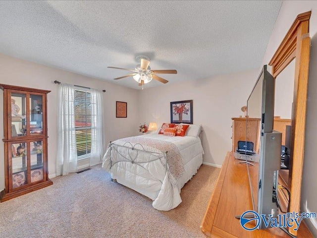 bedroom with light carpet, a textured ceiling, and ceiling fan