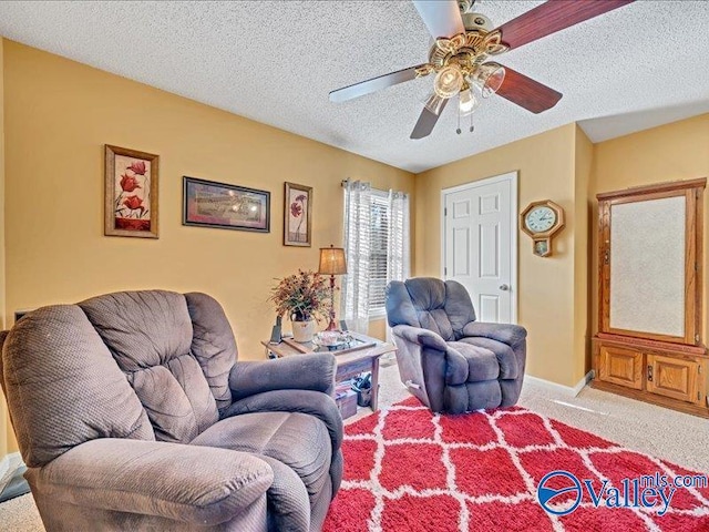 living room featuring ceiling fan, light carpet, and a textured ceiling