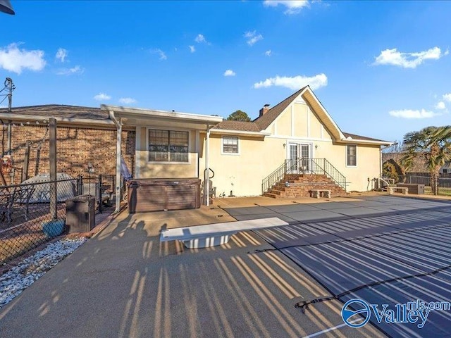 rear view of house featuring a hot tub