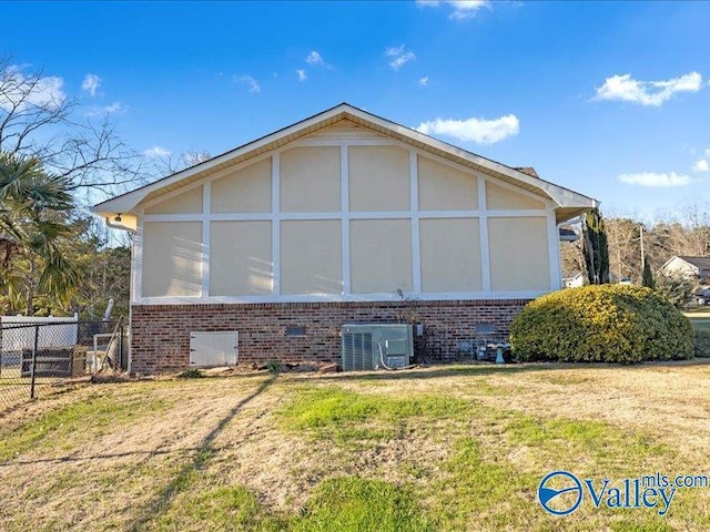 view of home's exterior featuring a sunroom, central AC unit, and a lawn