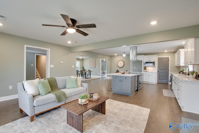 living room featuring sink, ceiling fan, and light hardwood / wood-style flooring