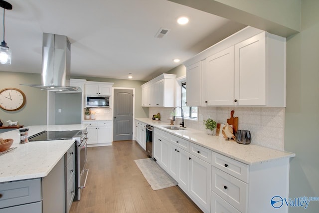 kitchen with stainless steel appliances, white cabinetry, sink, and pendant lighting