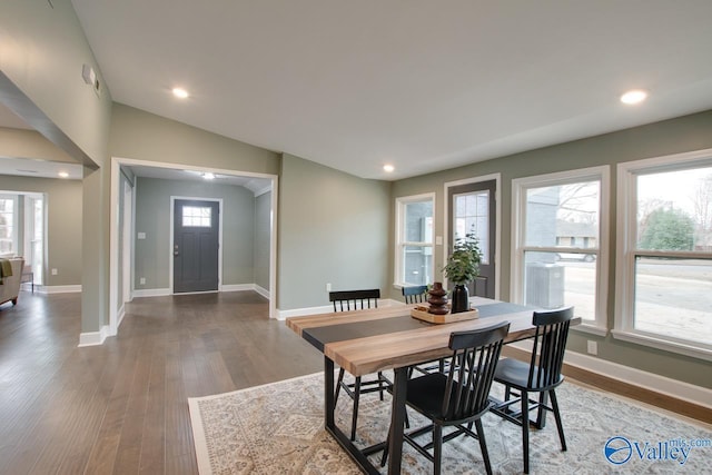 dining space featuring hardwood / wood-style flooring and vaulted ceiling