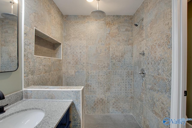 bathroom with vanity and tiled shower