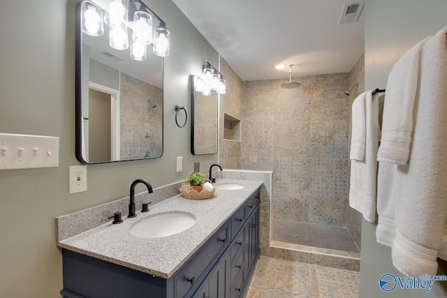 bathroom with vanity and tiled shower