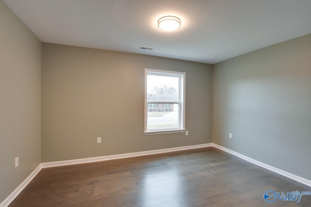 spare room featuring dark wood-type flooring