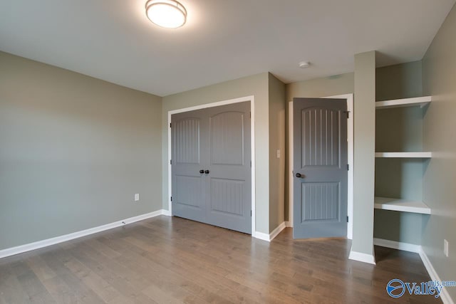 unfurnished bedroom with hardwood / wood-style floors and a closet