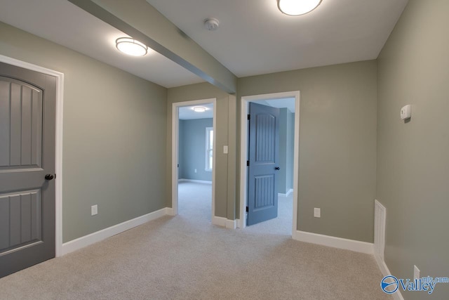 carpeted spare room featuring beam ceiling